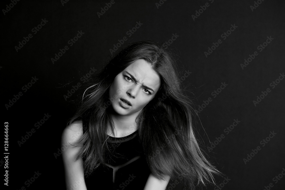 A young girl with long hair. Daring look in . BW