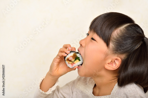 お寿司を美味しそうに食べる女の子