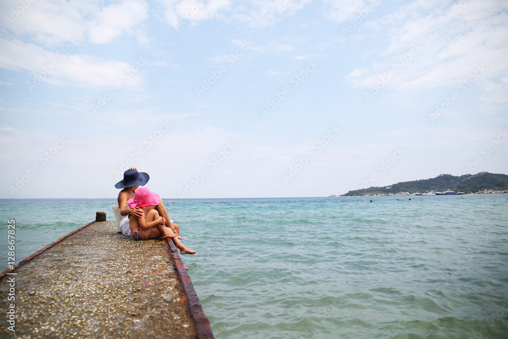 Mother and daughter on the deck at the beach Mother and daughter on the deck at the beach