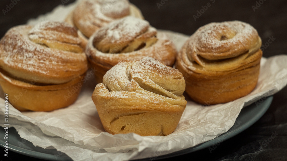 Homemade pastries cruffins, muffin with sugar powder, on dark background, selective focuse close up