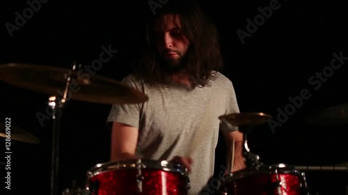 drummer playing on drums in a dark room, slow motion photo