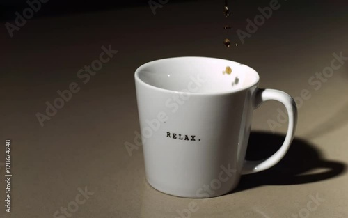 Super slow motion pouring of coffee into a coffee mug