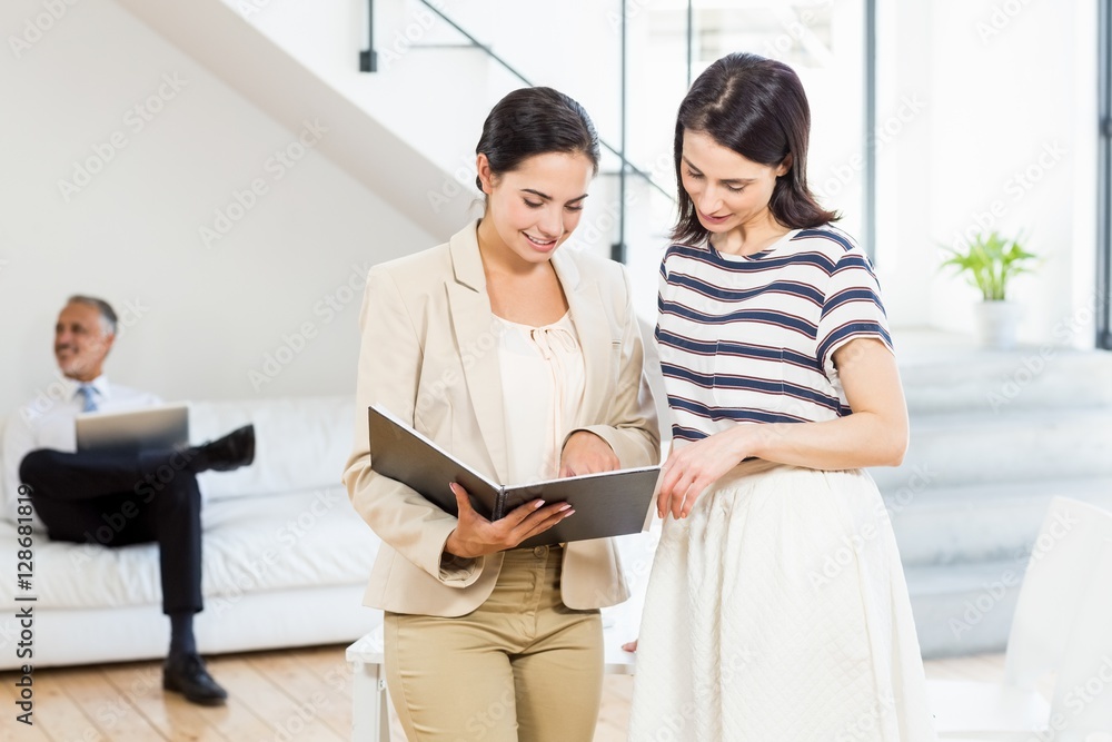Businesswoman and a colleague looking at diary Businesswoman and a colleague looking at diary