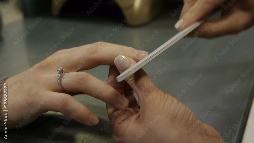 Manicurist makes manicure woman nail file Manicurist makes manicure woman nail file