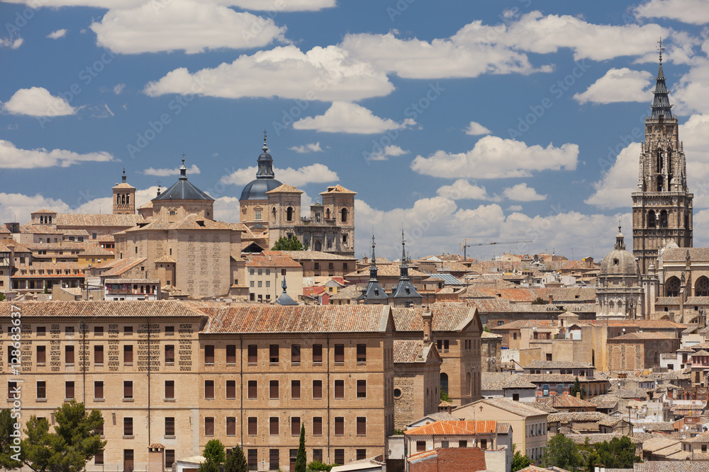 Skyline of Toledo with the Toledo Cathedral and other medieval houses on a blue sky filled with clouds 