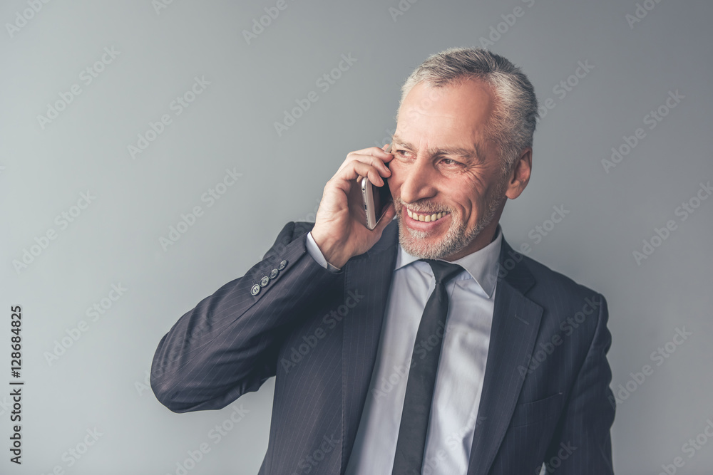 Handsome mature businessman with gadget Handsome mature businessman with gadget