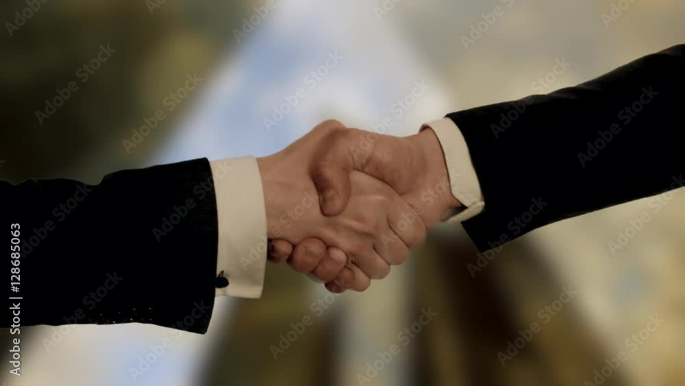 handshake of businessman - modern city background. handshake of businessman - modern city background.