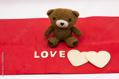 Bear with wooden heart on red background