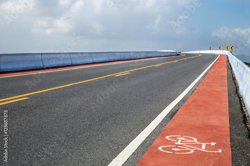 road with bicycle lane on bridge over the river © holwichaikawee