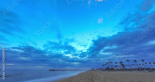 Sunset time lapse at the Newport Beach Pier at the beach with moving clouds and colors in the sky
