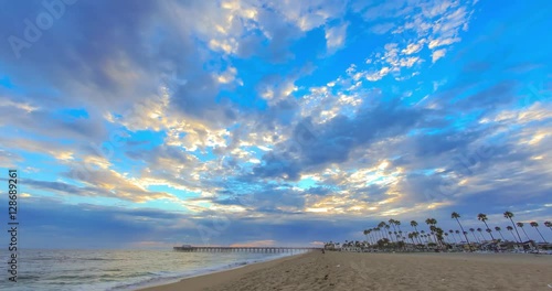 Sunset time lapse at the Newport Beach Pier at the beach with moving clouds and colors in the sky
