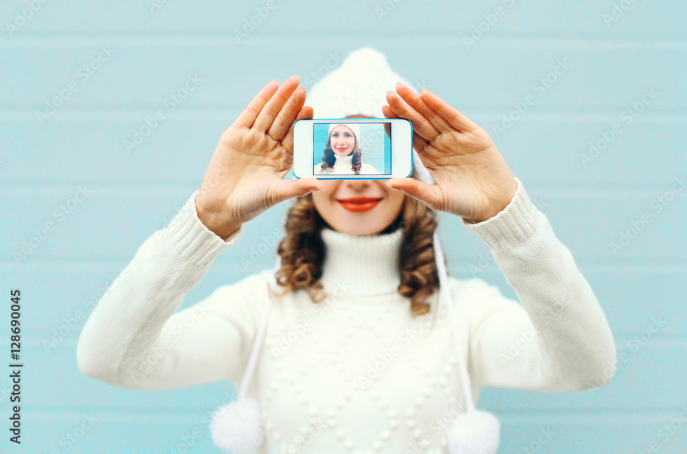 Fototapeta premium Happy pretty girl taking photo self portrait on smartphone over