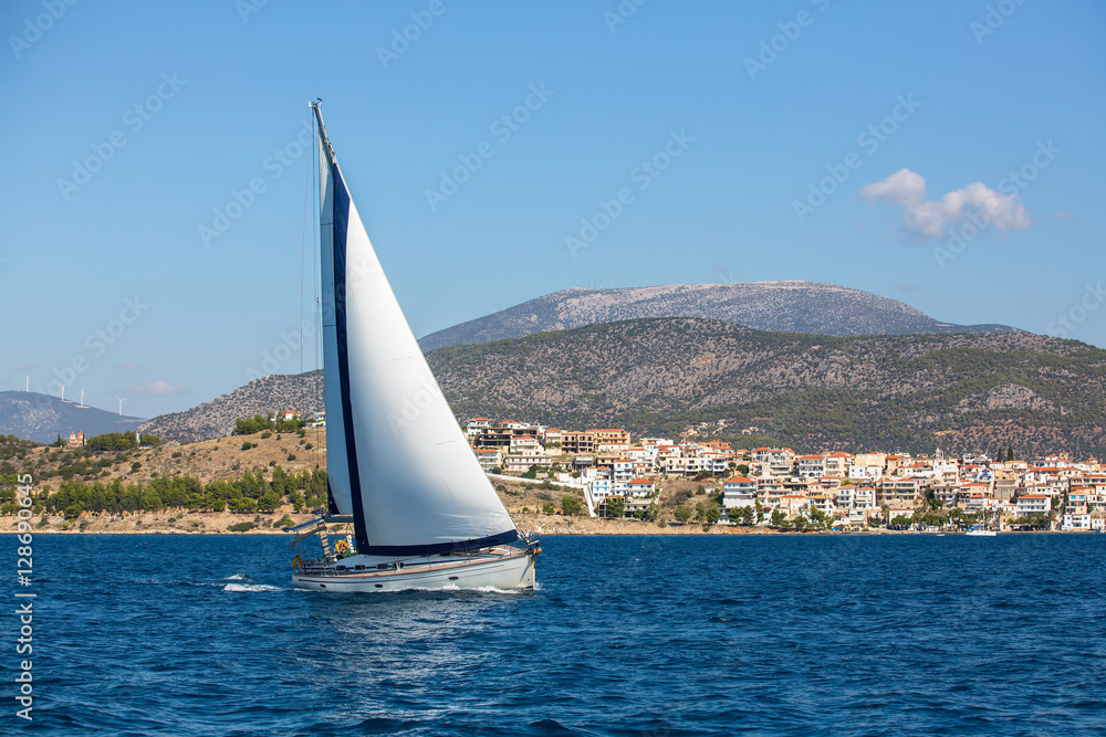 Luxury yacht boat at regatta. Sailing in the wind through the waves at the Aegean Sea.