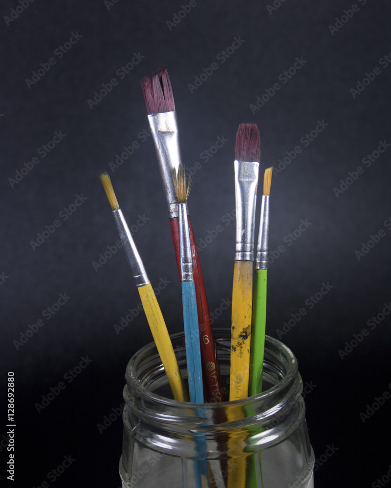 Naklejka premium paint brush on grungy black and white acrylic paint canvas