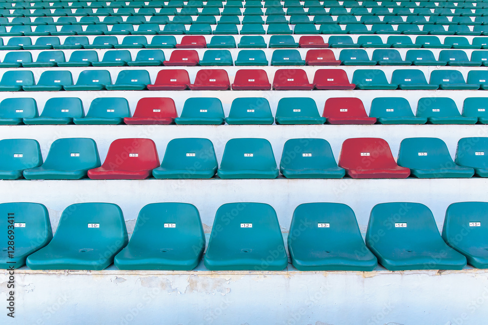 Obraz premium red seat or bench with letter H or home word in the middle or center of green chair in the stadium.