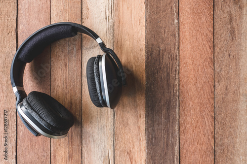 Top view of Headphones on wooden table background. 