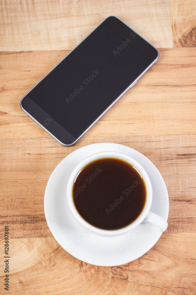 Mobile phone with blank screen and cup of coffee Mobile phone with blank screen and cup of coffee