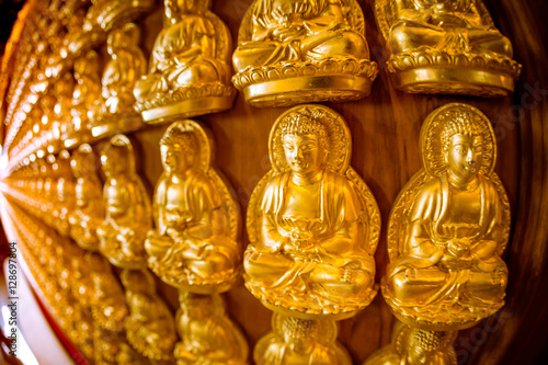 A wall full of golden buddha amulet.