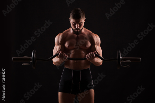 Closeup portrait of a muscular man workout with barbell at gym.