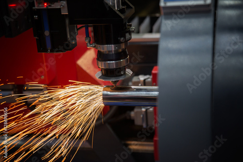 Cutting of sheet metal. Sparks fly from laser by automatic cutti photo