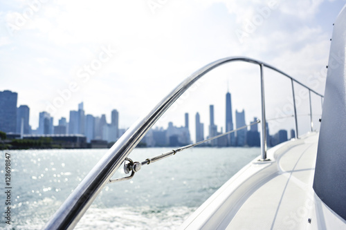 Luxury yacht overlooking abstract city skyline in the summertime. Money and wealth concept. 