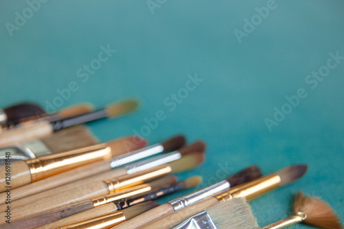 Lots of paintbrushes on colorful canvas background
