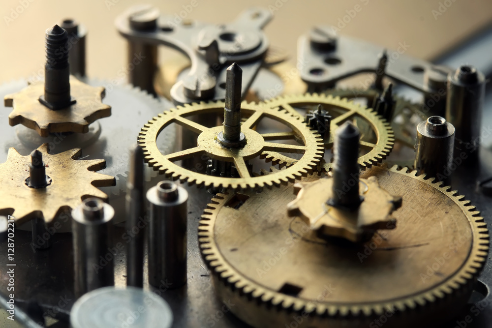 old clock mechanism with screws and gears disassembled