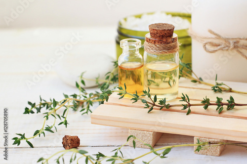 Thyme essential oil. Bottles with extract, fresh green plant leaves. Aromatherapy treatment. Botanic Spa. 