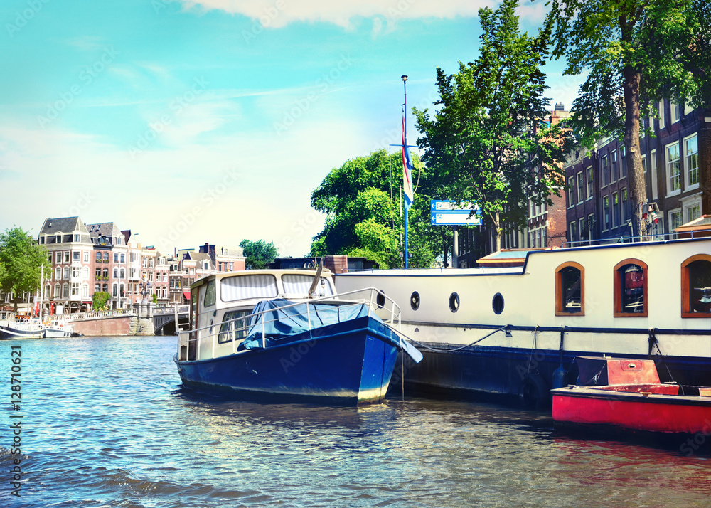 Amsterdam city scene of the Amstel river and anchored boats.