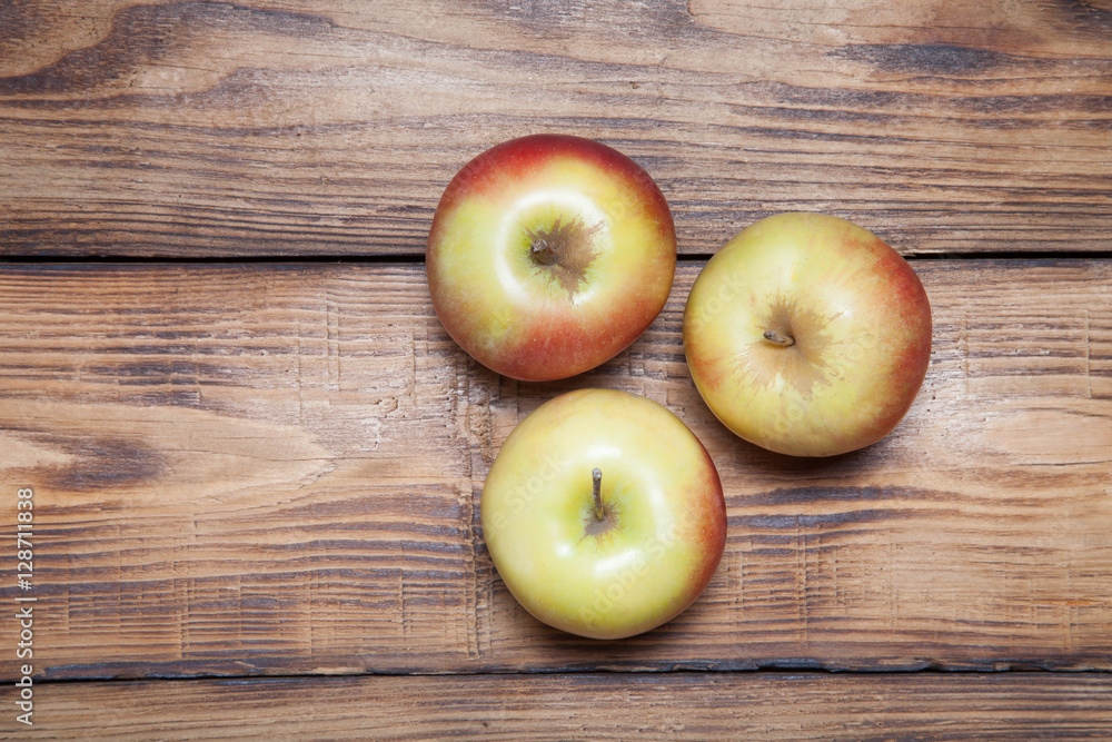 Yellow-red seasonal apples on the background of burned boards Yellow-red seasonal apples on the background of burned boards