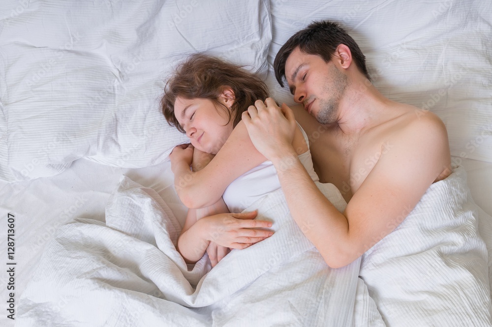 Young couple in love sleep together in bed. Stock Photo