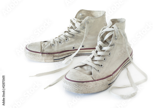 Old white sneakers on white background