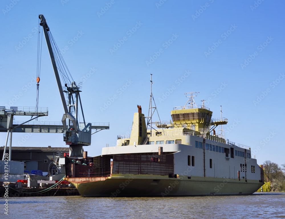 Freight shipping scene with industrial harbor cranes  and industrial ship in the sunset.