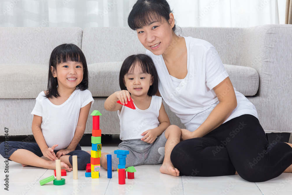 Asian Chinese mother and daughter playing blocks on the floor Asian Chinese mother and daughter playing blocks on the floor
