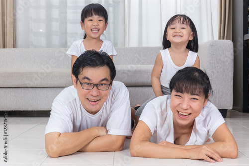 Happy Asian Chinese parents and daughters lying on the floor