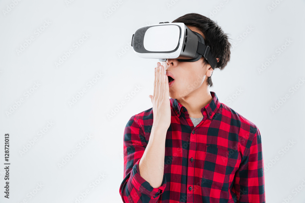 Surprised asian man dressed wearing virtual reality device Surprised asian man dressed wearing virtual reality device