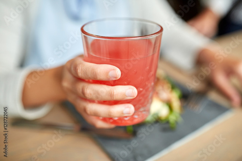 hand with glass of juice at restaurant