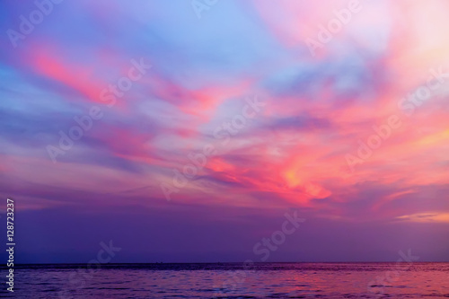 Tropical colorful dramatic sunset with cloudy sky and silhouette of the ship on the horizon. Evening calm on the Gulf of Thailand. Bright afterglow. © sonatalitravel