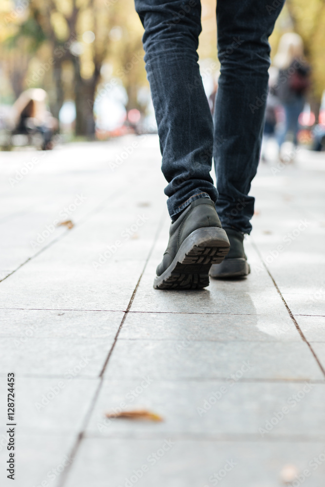 Cropped photo of young walking man on street Cropped photo of young walking man on street