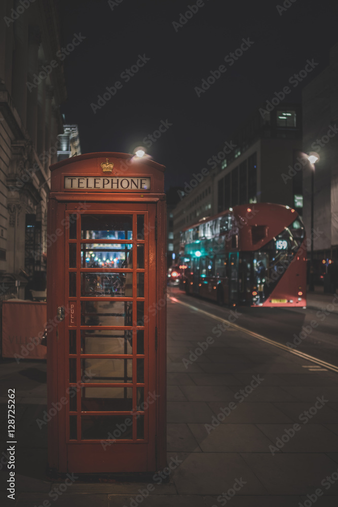 Fototapeta Londyńska budka telefoniczna w nocy z autobusem w tle