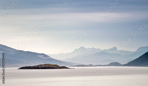 Coast of  Norway sea in clouds of haze. Beacon on a rock photo