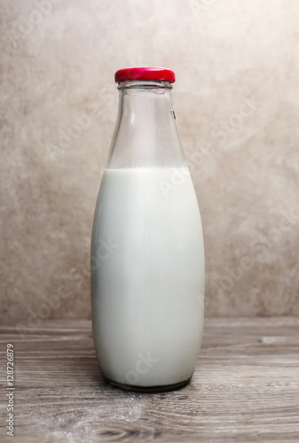glass milk bottle over sepia background