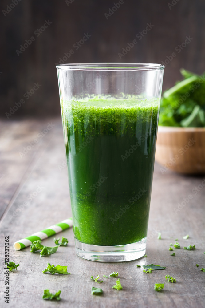 Kale smoothie in glass on wooden background.
Kale smoothie in glass on wooden background.