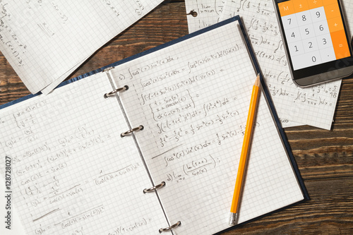 Mathematical equations written in a notebook. Calculator app.