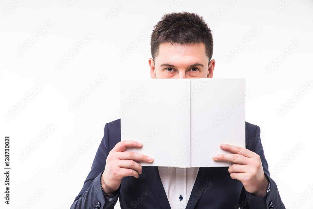 Young man in suit cover face with book over white background Young man in suit cover face with book over white background