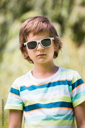A little boy is wearing sun glasses