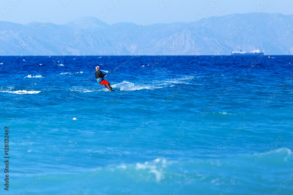 man has kite. Most popular places in Rhodes Greece for kitesurfing.