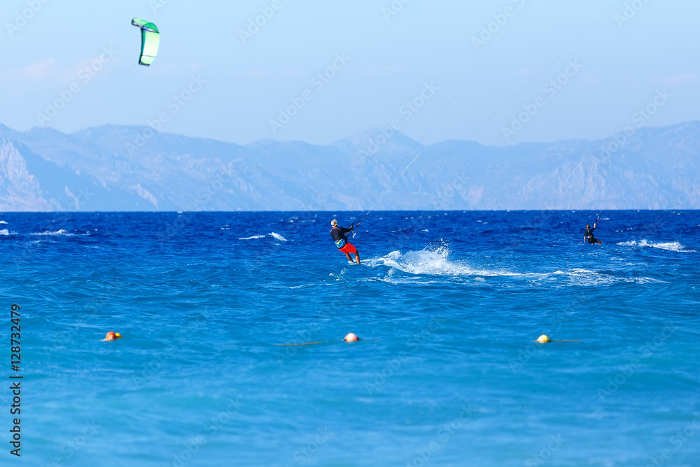 Kitesurfer in action on clear blue tropical water, Rhodes Island, Greece