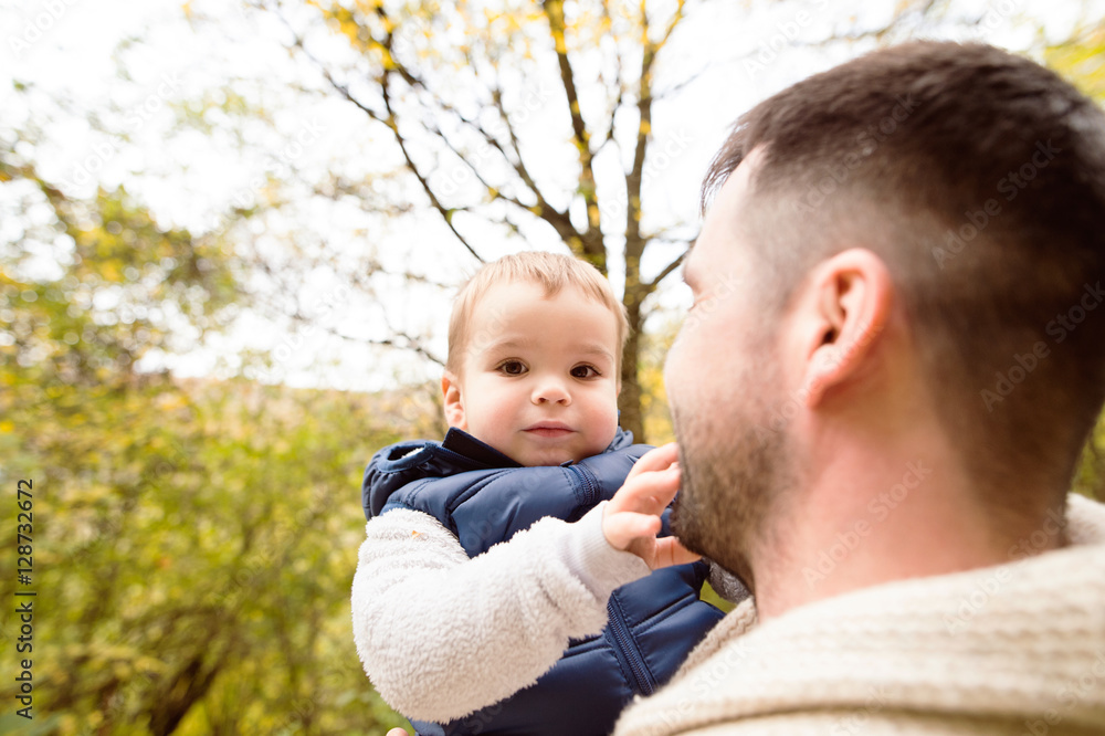 Unrecognizable father with his son in autumn forest. Unrecognizable father with his son in autumn forest.