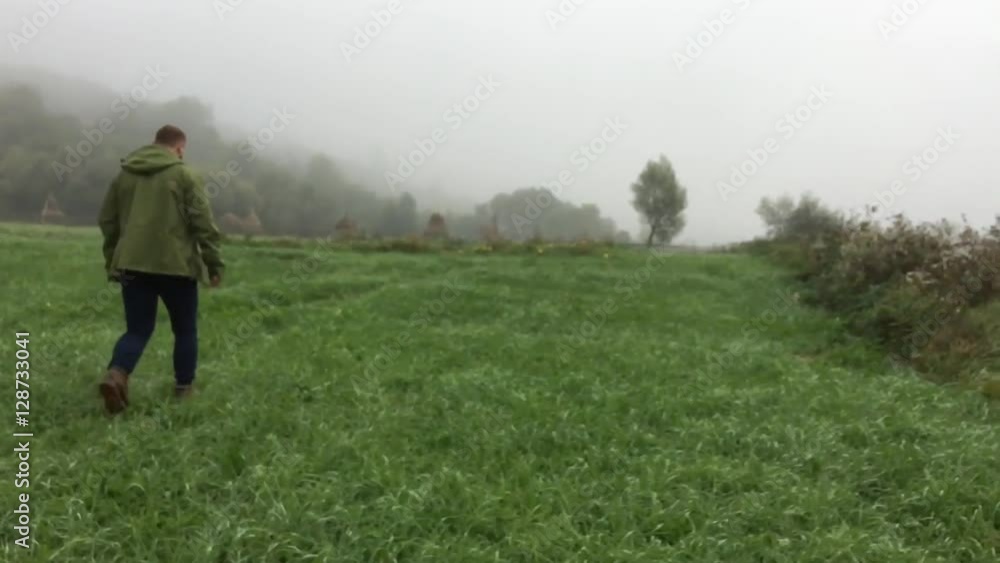 Man walk on the meadow in foggy morning. Slow motion. Man walk on the meadow in foggy morning. Slow motion.